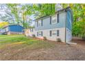 Side view of a charming two-story home with a white brick facade, blue siding, and well-maintained landscaping at 2046 Copperfield Cir, Decatur, GA 30035