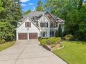 Attractive two-story home showcasing a two-car garage, stone details, and landscaped front yard at 1169 Dawn View Nw Ln, Atlanta, GA 30327