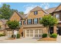 Charming brick townhome with a two-car garage and manicured landscaping on a sunny day at 4150 Cedar Bridge Walk, Suwanee, GA 30024