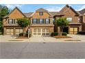 Beautiful brick townhome featuring a two-car garage and a meticulously maintained front yard at 4150 Cedar Bridge Walk, Suwanee, GA 30024