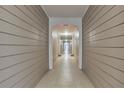 Long hallway with beige plank walls and off-white tile flooring, leading to a bright entrance at 4333 Dunwoody Park # 2107, Atlanta, GA 30338