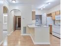 Cozy kitchen with wood cabinets, white appliances, and laminate flooring flowing into the dining area at 4333 Dunwoody Park # 2107, Atlanta, GA 30338
