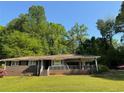 Brick home with a covered front porch and lush green lawn surrounded by mature trees at 4416 Arcadia Dr, Norcross, GA 30093