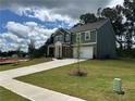 Charming two-story home with a well-maintained lawn, stone accents, and an attached two-car garage at 5377 Heron Bay Blvd, Locust Grove, GA 30248