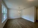 Bright and spacious living room featuring new hardwood floors, a chandelier, and large windows for natural light at 5377 Heron Bay Blvd, Locust Grove, GA 30248