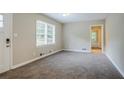 A bright living room with neutral walls, large window, and new carpet flooring at 2529 Habersham Dr, Decatur, GA 30032