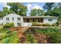 Charming brick home with a welcoming front porch and mature trees, perfect for outdoor relaxation at 7300 Wynhill Dr, Sandy Springs, GA 30328