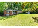 Charming brick ranch home with a well-manicured lawn, mature trees, and inviting curb appeal at 6651 Castleton Dr, Atlanta, GA 30328