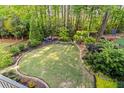 Expansive backyard featuring lush landscaping, well-manicured lawn, border gardens, and a charming seating area at 127 Marlow Dr, Woodstock, GA 30188