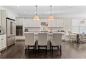 Bright, modern kitchen with white cabinets, stainless steel appliances, large island with seating, and hardwood floors at 127 Marlow Dr, Woodstock, GA 30188