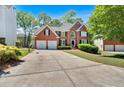 Lovely brick home with a spacious driveway, two-car garage, and mature landscaping at 3921 Upland Way, Marietta, GA 30066