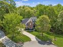 Aerial view of a two-story brick home surrounded by lush greenery and a winding driveway at 4750 Spring Wood Trce, Cumming, GA 30041