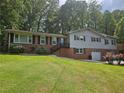 Charming two-story home featuring a brick exterior, a manicured lawn, and beautiful shrubbery at 1513 Wildwood Dr, Acworth, GA 30102