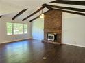 Spacious living room with hardwood floors, vaulted ceilings, and a brick fireplace at 1513 Wildwood Dr, Acworth, GA 30102