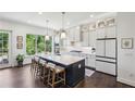 Modern kitchen with a large island, white cabinets, quartz countertops, and stainless steel appliances at 476 Springer Nw Bnd, Marietta, GA 30060