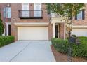 Paved driveway leads to an attached two-car garage with a neatly trimmed shrub border at 478 Vinings Estates Se Dr # B02, Smyrna, GA 30126