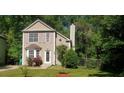 Inviting two-story home featuring a well-maintained lawn, complemented by lush greenery and mature trees at 728 Brittany Ct, Stone Mountain, GA 30083