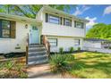 Charming two-story home with a brick facade, wooden shutters, landscaped yard, and a welcoming light blue front door at 3180 Spring St, South Fulton, GA 30349