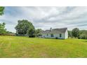 Wide backyard showcasing a well-maintained lawn and the home's exterior, extending to mature trees at 472 Linda Ln, Powder Springs, GA 30127