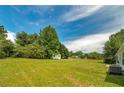Expansive backyard with lush green grass, mature trees, and a small outbuilding, perfect for outdoor activities at 472 Linda Ln, Powder Springs, GA 30127