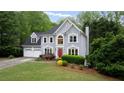 Charming two-story home featuring a red front door and lush landscaping at 681 Braidwood Nw Ter, Acworth, GA 30101