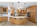 A traditional style kitchen offers a spacious island and custom wood cabinetry and modern lighting at 681 Braidwood Nw Ter, Acworth, GA 30101