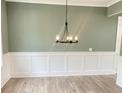 Dining room featuring wainscoting, a modern chandelier, and ample space for entertaining at 3355 Hillshire Dr, Cumming, GA 30028