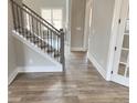 Elegant entryway showcasing hardwood floors, a staircase with iron balusters, and natural light at 3355 Hillshire Dr, Cumming, GA 30028
