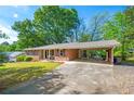Well-maintained brick home with covered parking and lush green lawn at 205 Corinth Ct, Roswell, GA 30075