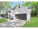 Side view of a beautiful two-story home with white brick and black garage door surrounded by green grass at 275 Carriage Chase, Fayetteville, GA 30214