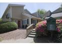 Inviting townhouse showcasing a well-maintained exterior with a stone walkway, manicured shrubs, and a pet waste station at 1468 Briarwood Ne Rd # 703, Atlanta, GA 30319