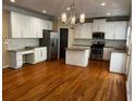 Spacious kitchen featuring white cabinets, stainless steel appliances, granite countertops, and hardwood floors at 5679 Coopers Glen Ct, Mableton, GA 30126