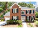 Beautiful brick home with black shutters and a well-manicured front lawn at 11140 Brookhollow Trl, Alpharetta, GA 30022