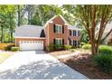 Traditional brick home with an attached garage and a spacious driveway at 11140 Brookhollow Trl, Alpharetta, GA 30022