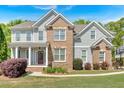 Charming home featuring a brick and siding facade, a well-manicured lawn, and a welcoming front porch at 120 Generals Pl, Canton, GA 30114