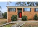 Brick home featuring black shutters, a red front door and a manicured yard at 3344 Northcrest Rd # A, Atlanta, GA 30340