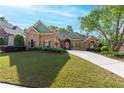 Beautiful stone house featuring lush green lawn, mature landscaping and well maintained lawn at 2111 Democracy Dr, Buford, GA 30519