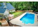Backyard view of a stunning pool area with ample seating, a hot tub, and lush green surroundings at 436 Westlake Nw Dr, Marietta, GA 30064