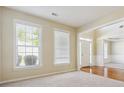 Inviting living room featuring large windows and neutral carpeting at 1520 Ethans Way, Mcdonough, GA 30252