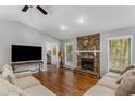 Cozy living room featuring a stone fireplace and lots of natural light at 204 Holly Creek Way, Woodstock, GA 30188