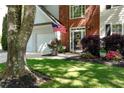 Beautifully landscaped front yard with lush lawn, colorful flowers, and shrubbery surrounding the home's entrance at 2264 Howell Farms Nw Trl, Acworth, GA 30101