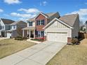 Attractive two-story home showcasing a well-maintained lawn, brick accents, a front porch, and an attached garage at 441 Spring View Dr, Woodstock, GA 30188