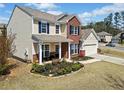 Inviting two-story home with brick and siding, front porch, landscaped garden, and attached two-car garage at 441 Spring View Dr, Woodstock, GA 30188