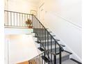 Classic stairway featuring black iron railings, white wainscoting, and carpeted steps at 1634 Ponce De Leon Ne Ave # 506, Atlanta, GA 30307