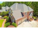 Lovely brick home featuring an attached garage, manicured landscaping, and a lush lawn at 2644 Nutwood Trce, Duluth, GA 30097
