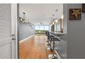 Modern living room with hardwood floors, bar seating, pendant lights, and large windows at 3338 Peachtree Ne Rd # 1010, Atlanta, GA 30326