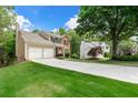 Spacious home featuring a long driveway, a two-car garage, and a beautifully landscaped front yard at 7260 Foxberry Ct, Cumming, GA 30041