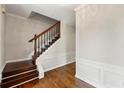 Welcoming foyer featuring hardwood floors, elegant wainscoting, and a staircase with dark wood railings at 7260 Foxberry Ct, Cumming, GA 30041