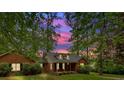 Brick home at sunset, framed by tall trees and beautiful landscaping at 151 Mark Se Ln, Smyrna, GA 30082
