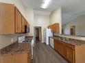 Well-lit kitchen with wood cabinets, laminate counters, and appliances ready for cooking at 16 Grandview Ct, Powder Springs, GA 30127